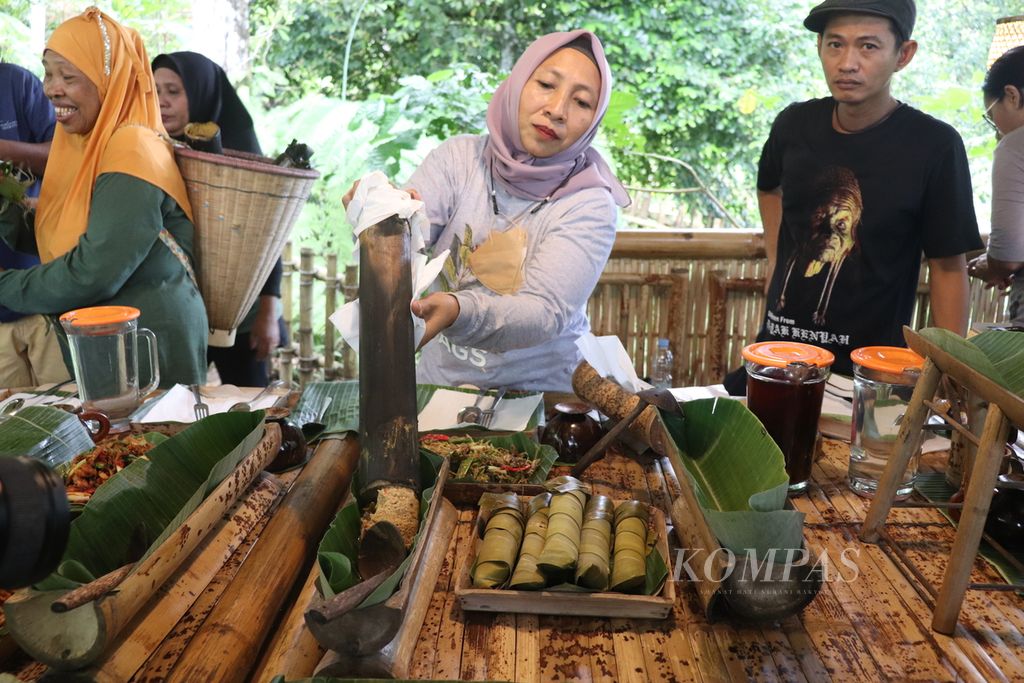 Chef Komunitas Cengkeh Afo dan Rempah Gamalam Norma A Badu (47, tengah) menyajikan makanan tradisional dari bambu di Kelurahan Tongole, Kecamatan Ternate Tengah, Kota Ternate, Maluku Utara, Selasa (29/3/2022). Komunitas Cengkeh Afi dan Rempah Galama menyediakan berbagai jenis makanan tradisional untuk dikonsumsi tamu atau wisatawan.