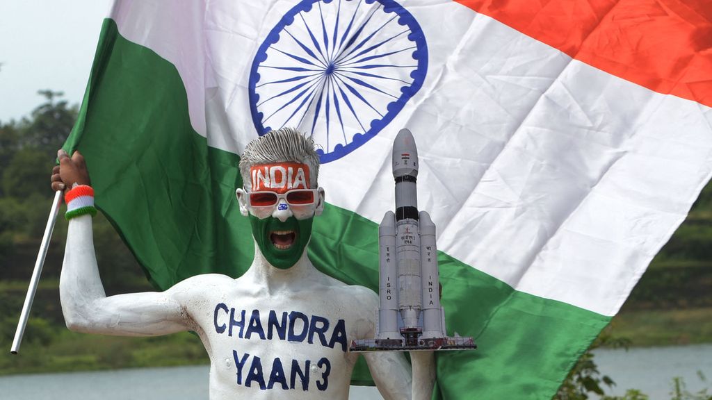 Seorang pria di Ahmedabad, India, memegang bendera India untuk merayakan pendaratan wahana antariksa India dalam misi Chandrayaan-3 di kutub selatan Bulan, 23 Agustus 2023. 