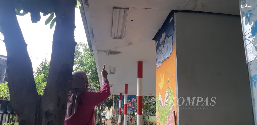 Seorang pengelola RPTRA Kebon Sirih, Gondangdia, Jakarta Pusat, menunjukkan titik plafon yang rusak, Jumat (15/4/2022).
