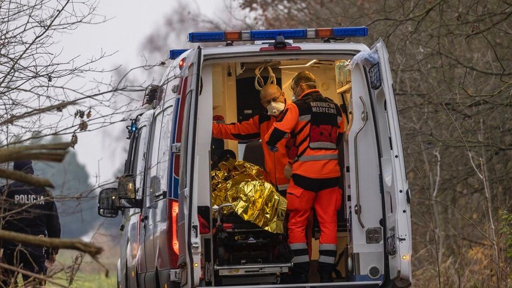 Paramedis membawa seorang pengungsi yang terluka ke ambulans ketika polisi dan petugas penjaga perbatasan menahan para pengungsi di dekat perbatasan Polandia-Belarus di Hajnowka, Polandia, Kamis (11/11/2021). 