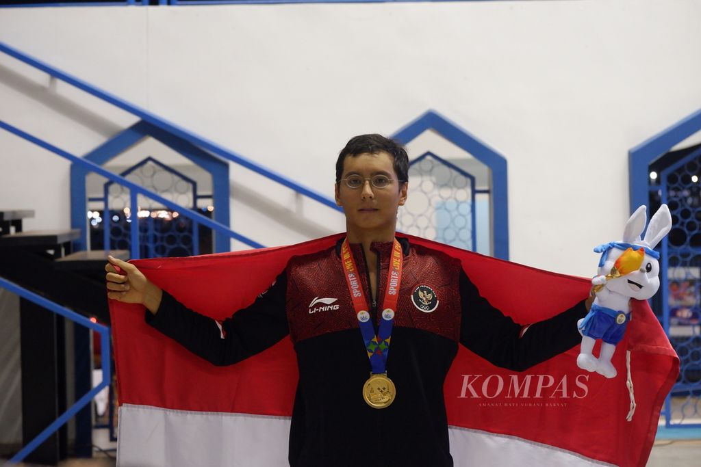 Perenang 50 meter gaya dada Indonesia, Felix Viktor Iberle (tengah), berpose setelah pengalungan medali SEA Games Kamboja 2023 di Akuatik Center Kompleks Olahraga Morodok Techo, Kamis (11/5/2023).
