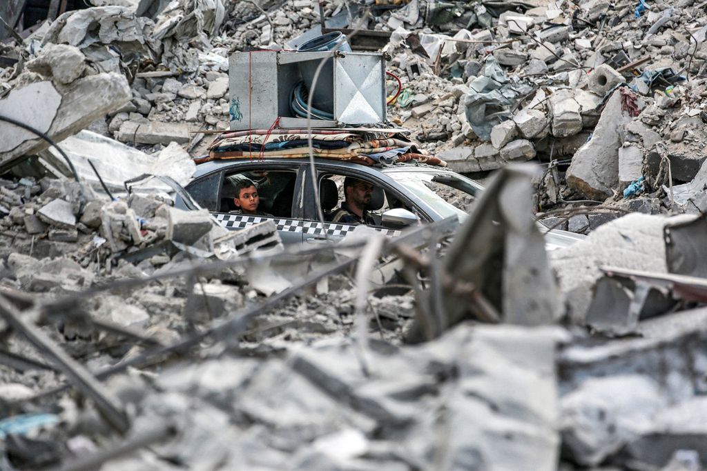 A vehicle moves past the rubble of collapsed buildings in Khan Yunis in the southern Gaza Strip on September 16, 2024, amid the ongoing war in the Palestinian territory between Israel and Hamas. (Photo by Bashar TALEB / AFP)