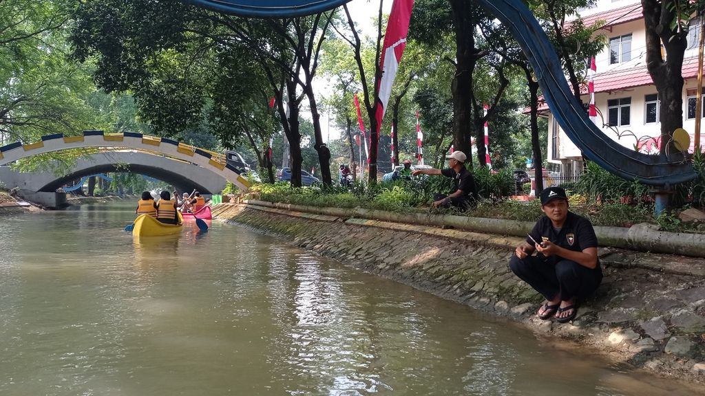 Tim Brigade 1016 atau petugas taman dari Dinas Kebudayaan dan Pariwisata Kota Tangerang mengawasi warga yang naik kano dari tepi Kali Sipon, Kota Tangerang, Banten, Sabtu (20/8/2022). Mereka memastikan keamanan dan keselamatan wisata air tersebut.
