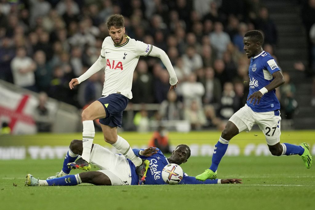 Pemain Everton Amadou Onana (bawah) mencoba mentekel pemain Tottenham Hotspur, Rodrigo Bentancur, dalam pertandingan Liga Inggris antara Tottenham Hotspur dan Everton di Stadion Tottenham Hotspur, London, Minggu (16/10/2022). 