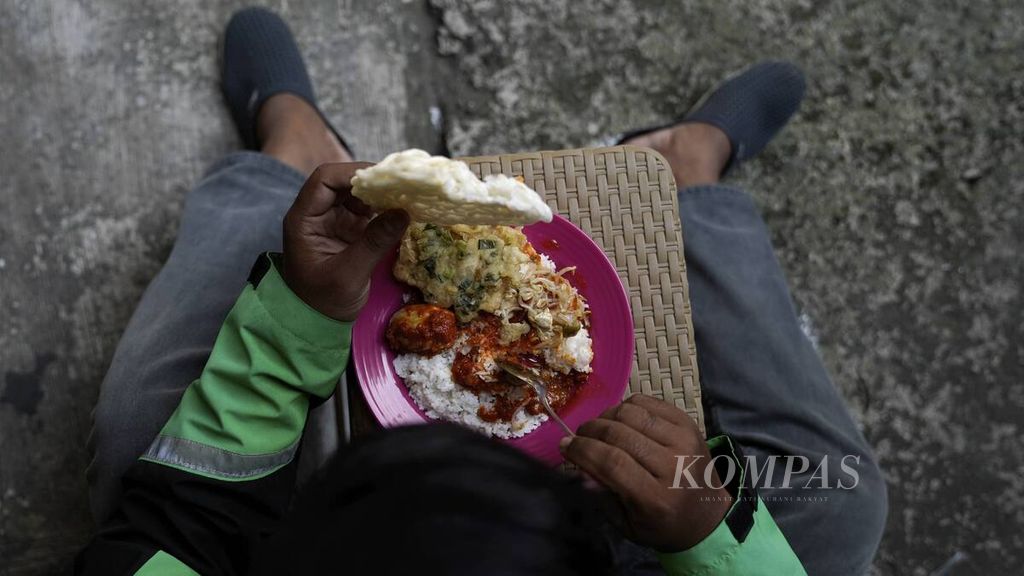 Pengojek daring sedang makan di Jalan Basuki Rachmat, Jakarta Timur, Selasa (28/7/2020). 
