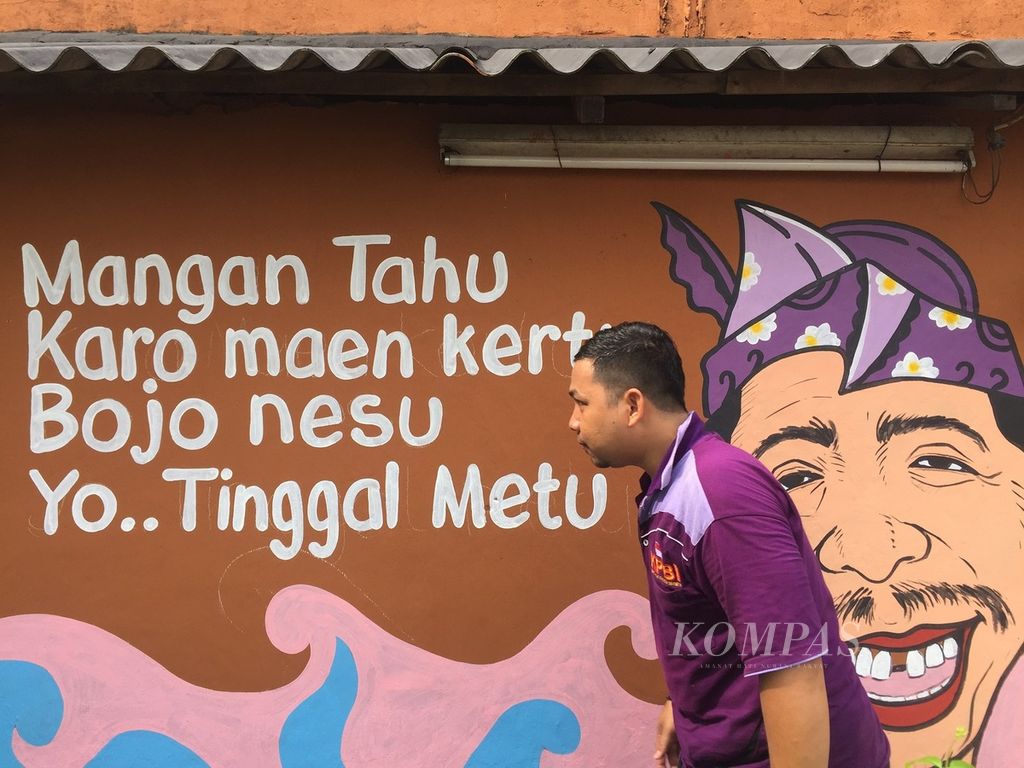 Dinding-dinding yang dihiasi pantun atau parikan suroboyoan di RW 004 Morokrembangan, Krembangan, Surabaya, Jawa Timur.