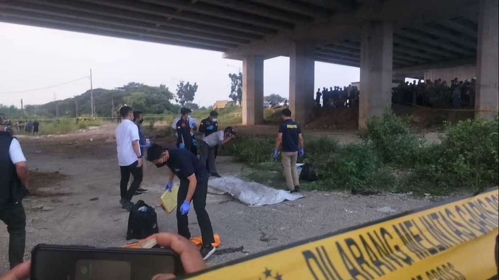 Polisi memeriksa sesosok mayat di dalam karung di kolong Tol Cibitung-Cilincing, Jakarta Utara, yang ditemukan pada Sabtu (27/5/2023). Dua pelaku berinisial VWA (54) dan MF (52) ditangkap polisi di kawasan Tanah Abang, Jakarta Pusat, pada Minggu (28/5/2023). Kronologi dan motif pembunuhan yang dilakukan keduanya masih diselidiki oleh polisi.