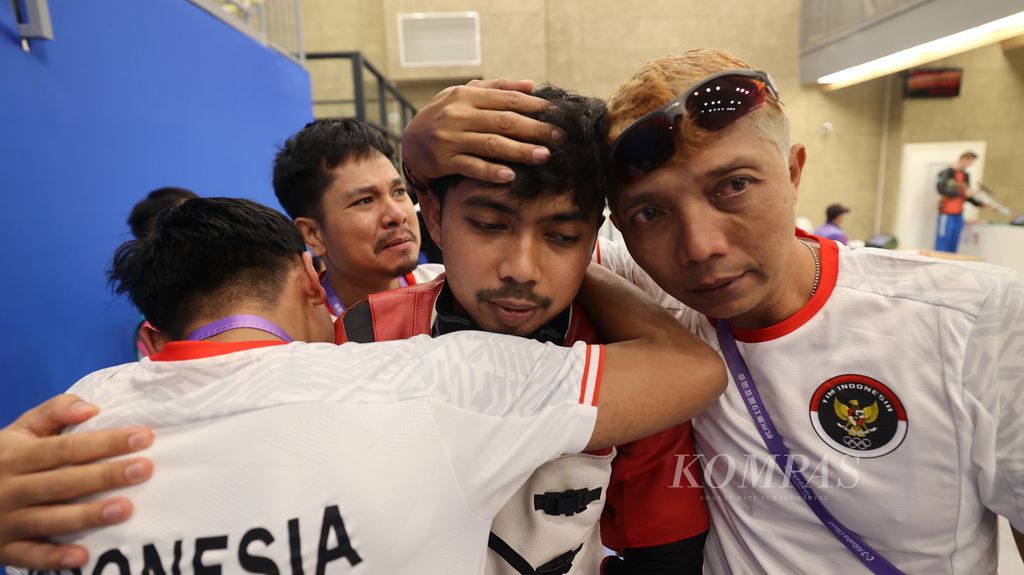 Indonesian shooter, Muhammad Sejahtera Dwi Putra (second from right), hugs Muhammad Badri Akbar and coaches, Masruri (right) and Irfandi Julio (back), after donating gold in the men's 10 meter running target mixed event. Hangzhou Asian Games 2022 at Fuyang Yinhu Sports Center, Hangzhou, China, Tuesday (26/9/2023).