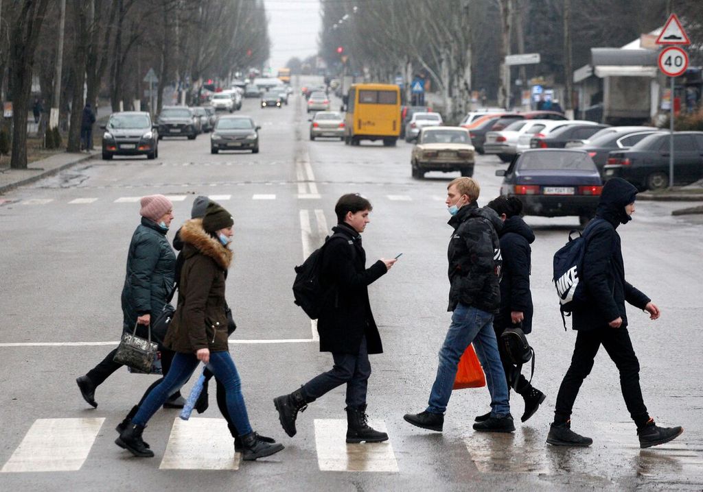 Para pejalan kaki menyeberang jalan di kota Kramatorsk, Ukraina timur, sekitar 50 kilometer dari garis depan pertempuran antara pasukan Ukraina dan pasukan separatis dukungan Rusia, 18 Februari 2022. 