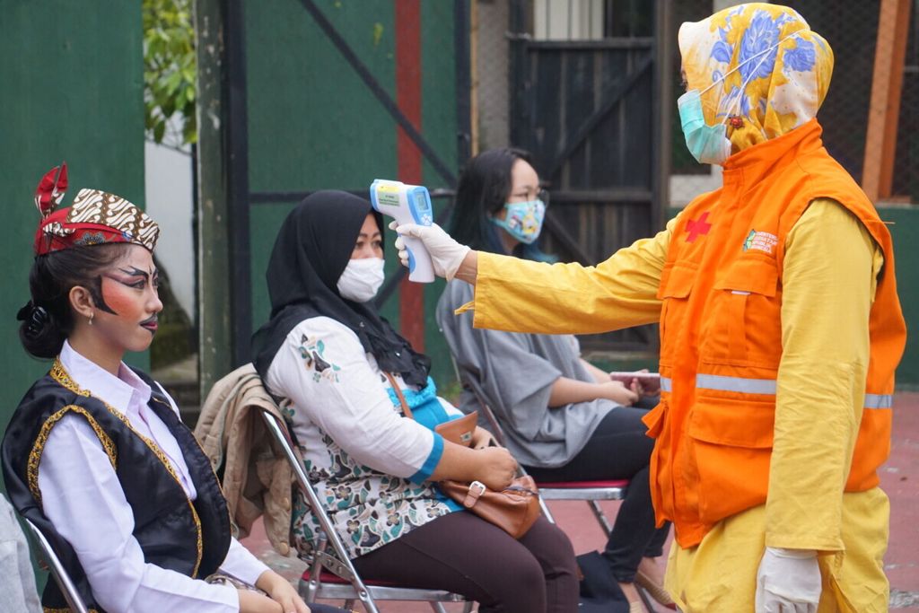 Petugas kesehatan memeriksa suhu tubuh penari sebelum tampil di pertunjukan virtual bertajuk “Kangen Manggung” di Purbalingga, Jawa Tengah, Sabtu (16/5/2020).