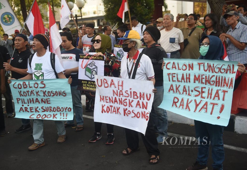 Dengan membawa poster, warga dari gerakan coblos kotak kosong berunjuk rasa di depan Kantor DPRD Surabaya, Jawa Timur, Selasa (17/9/2024). Unjuk rasa merupakan bentuk protes dan perlawanan terhadap para pemimpin partai yang telah gagal menyerap aspirasi rakyat. Mereka mengajak warga untuk mencoblos kotak kosong. Dalam Pilkada Surabaya, pasangan yang mendaftar sebagai calon wali kota dan wakil wali kota adalah pasangan petahana, yaitu Eri Cahyadi dan Armuji. 