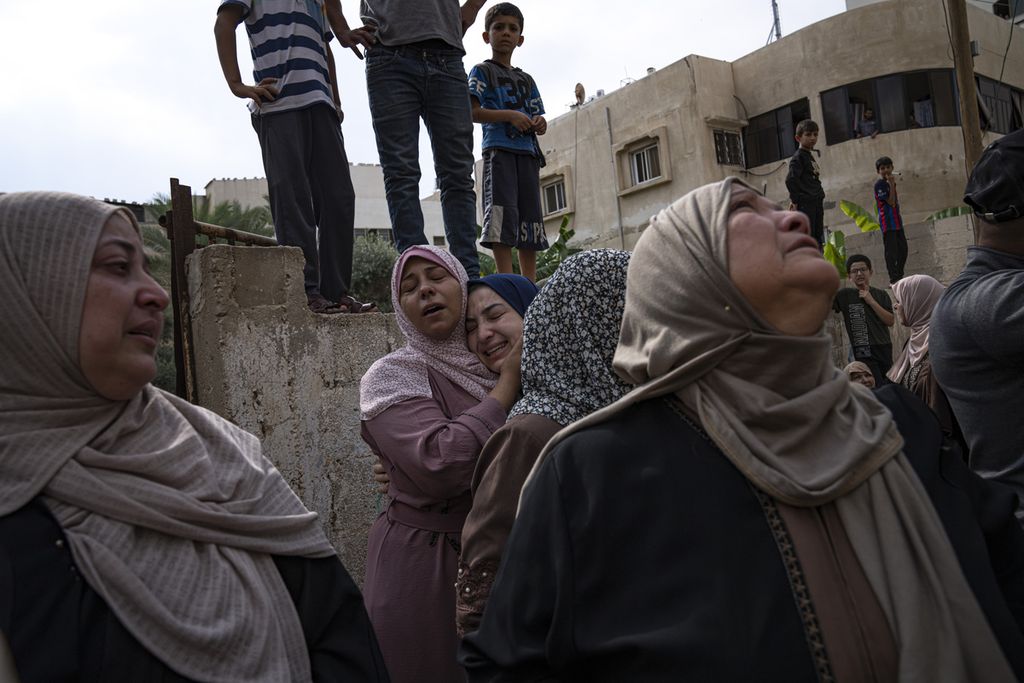 Kerabat berduka atas tewasnya korban dalam serangan udara Israel di kota Gaza, Senin (9/10/2023). 