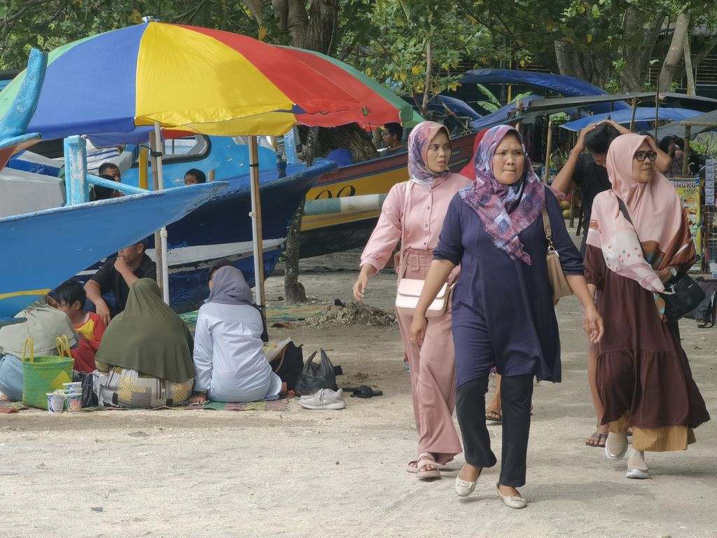 Sejumlah wisatawan berjalan-jalan di Pantai Senggigi, Batulayar, Lombok Barat, Nusa Tenggara Barat, Senin (26/12/2022) siang. 