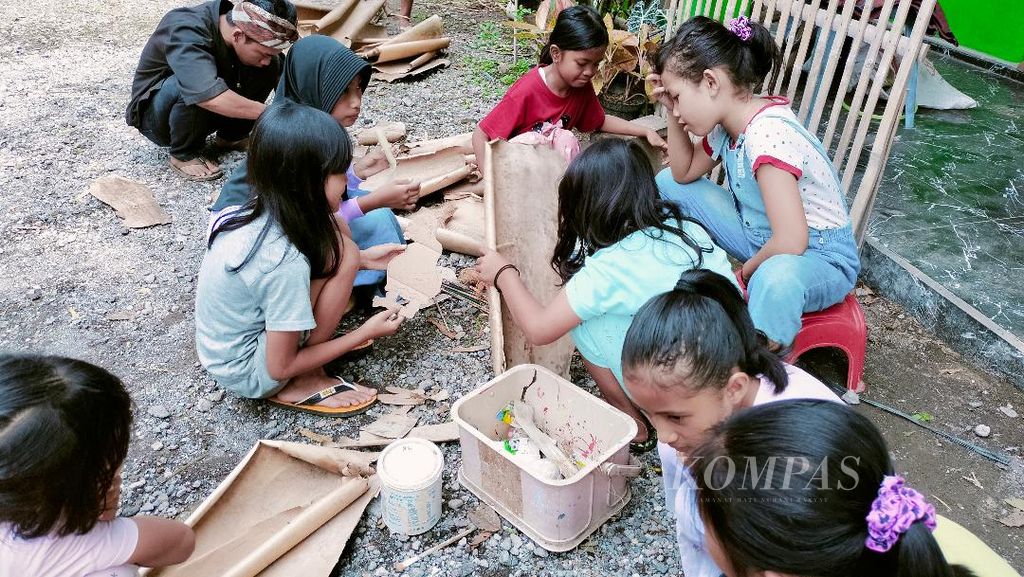 Anak-anak belajar membuat wayang dari bahan kulit bambu muda di halaman rumah Irfandi di Desa Giritengah, Kecamatan Borobudur, Kabupaten Magelang, Senin (4/12/2023).