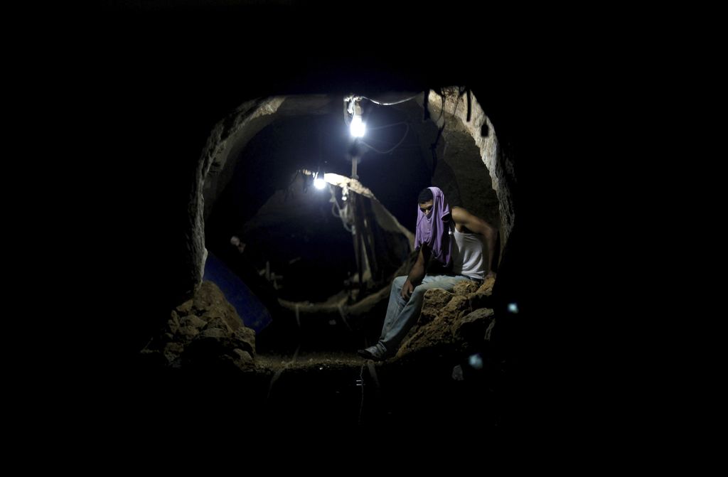Seorang pekerja Palestina beristirahat di dalam terowongan penyelundupan di Rafah, di perbatasan antara Mesir dan Jalur Gaza selatan, Senin (30/9/2013).