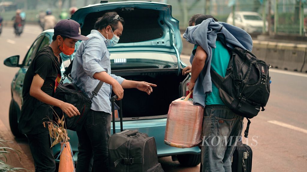 Pelaku perjalanan luar negeri dari Arab Saudi naik taksi seusai menjalani karantina kesehatan di Rumah Susun Pasar Rumput, Jakarta Selatan, Selasa (21/12/2021). 