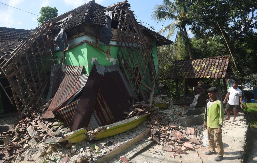 Warga berada di depan rumahnya yang hancur pascagempa di Desa Suwari, Kecamatan Sangkapura, Pulau Bawean, Kabupaten Gresik, Minggu (24/3/2024). 