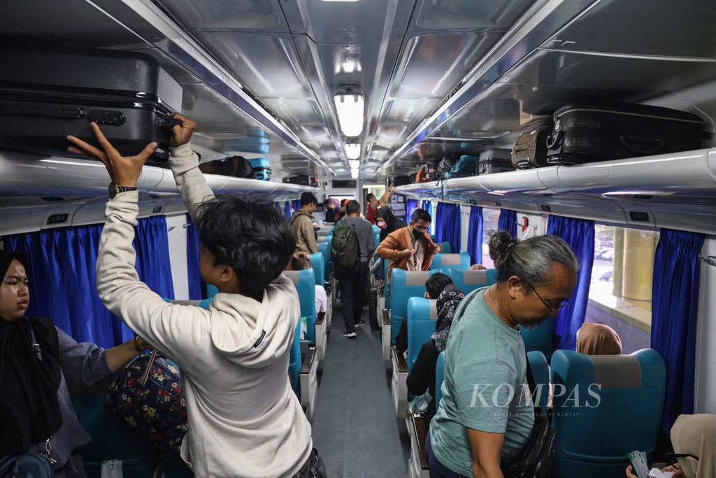 Penumpang menyimpan koper di dalam kereta di Stasiun Gambir, Jakarta Pusat, Kamis (21/12/2023). 