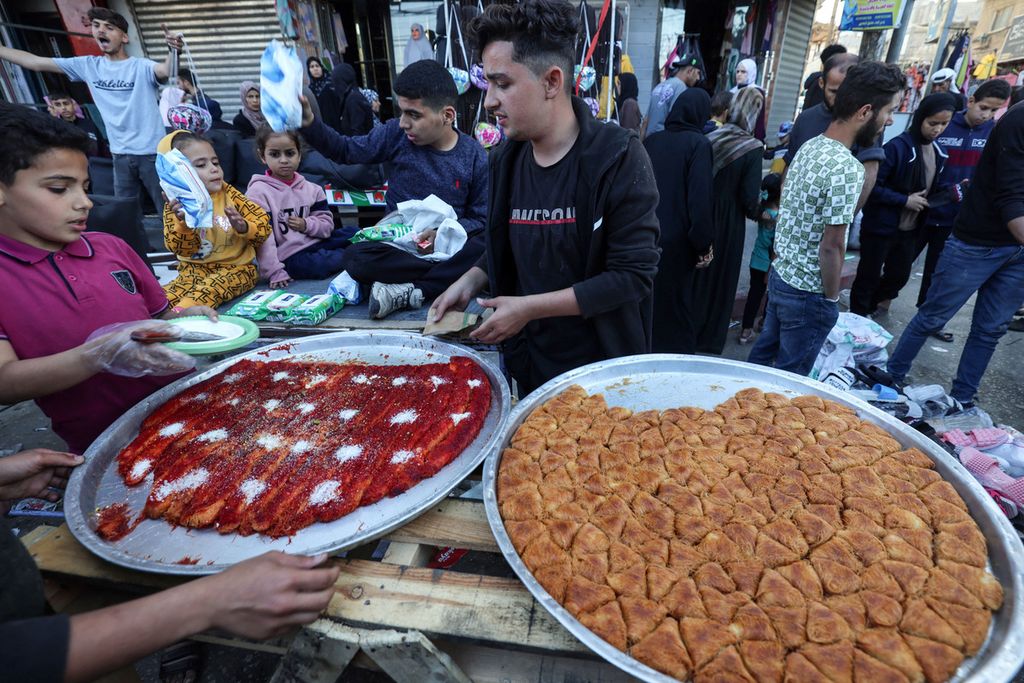 Pemuda penjual manisan di pasar terbuka di Rafah, Jalur Gaza selatan pada 9 April 2024, sehari menjelang Idul Fitri di kawasan itu. 