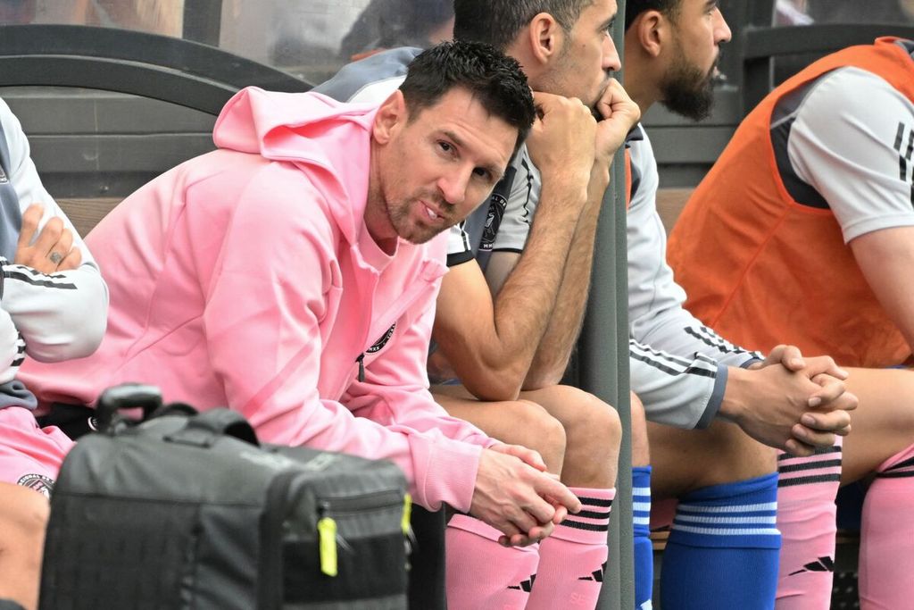 Pemain Inter Miami, Lionel Messi (kiri), duduk di bangku cadangan saat laga uji coba lawan Hong Kong XI di Hong Kong, Minggu (4/2/2024). Penonton marah karena Messi tak tampil pada laga itu.