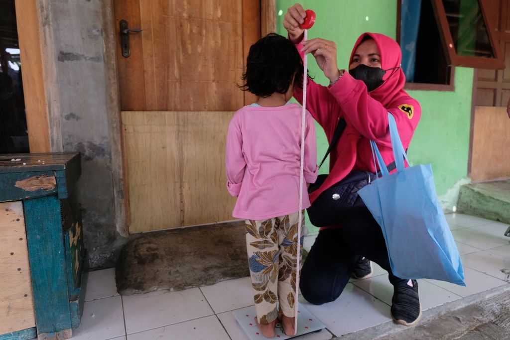 Seorang anak berumur 3 tahun 11 bulan dengan <i>stunting</i> atau tengkes diukur tinggi dan berat badannya di RW 009 Kelurahan Cakung Barat, Kecamatan Cakung, Jakarta Timur, Sabtu (8/4/2023). Kader posyandu setempat mengatakan setidaknya ada sembilan anak dengan <i>stunting</i> di RW tersebut. Mereka lantas diajak ikut program penanganan <i>stunting</i> antara lain dengan memberi anak-anak makanan tambahan, susu, dan vitamin. Berat badan dan tinggi badan anak pun dipantau oleh kader posyandu setiap minggu.