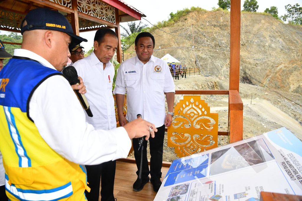 Presiden Joko Widodo mendengarkan penjelasan terkait kemajuan pembangunan Bendungan Bulango Ulu di Kabupaten Bone Bolango, Provinsi Gorontalo, Senin (22/4/2024). Bendungan multifungsi yang akan menampung 84 juta meter kubik air ini ditarget rampung akhir 2024.