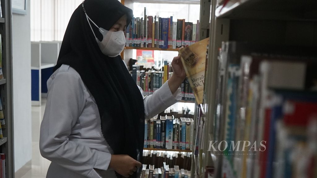 Seorang pengunjung sedang mengambil sebuah buku di perpustakaan Kantor Dinas Perpustakaan dan Kearsipan Kota Palembang, Selasa, (17/1/2023). Minat baca warga Palembang masih rendah karena kurangnya jenis bacaan yang menarik. Sejumlah upaya dilakukan untuk mendongkrak minat baca warga Palembang.