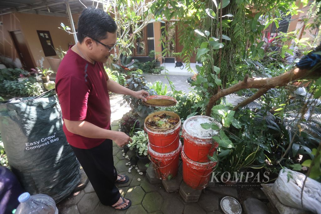 Sansu Suranto (44) menggunakan sistem ember tumpuk untuk mengolah sampah organik menjadi pupuk di halaman rumahnya di Desa Panggungharjo, Sewon, Bantul, DI Yogyakarta, Rabu (2/8/2023). 