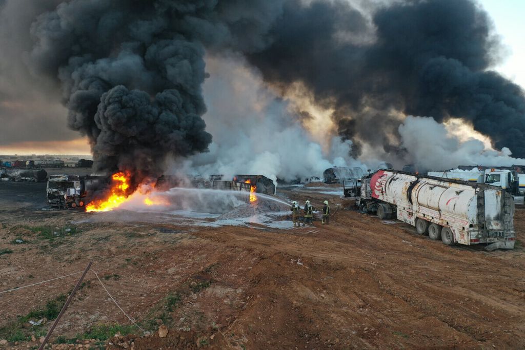 In this photo provided Saturday, March 6, 2021  by the Syrian Civil Defense group known as the White Helmets, Civil Defense workers extinguish burning oil tanker trucks after a suspected missile strike around the towns of Jarablus and al-Bab, near the border with Turkey, in western Aleppo province, Syria. Syrian opposition groups and the Syrian Observatory for Human Rights, based in Britain, blamed Russia for the Friday night strikes.