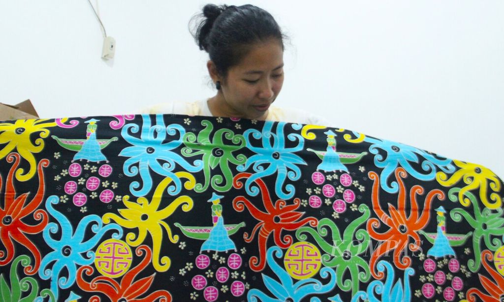 Priska Yeniriatno (34), pemilik Galeri Kote Singkawang yang juga tukang batik, sedang menunjukkan batik hasil karyanya, Sabtu (26/6/2022).
