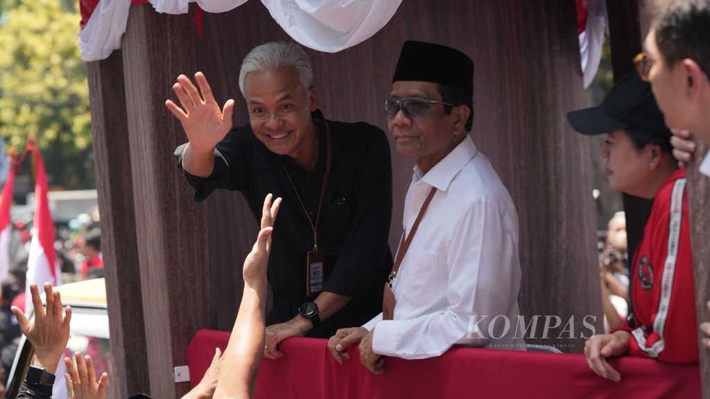Pasangan bakal calon presiden dan bakal calon wakil presiden Ganjar Pranowo dan Mahfud MD naik kendaraan bak terbuka untuk mendaftar di kantor Komisi Pemilihan Umum, Jakarta, Kamis (19/10/2023). 