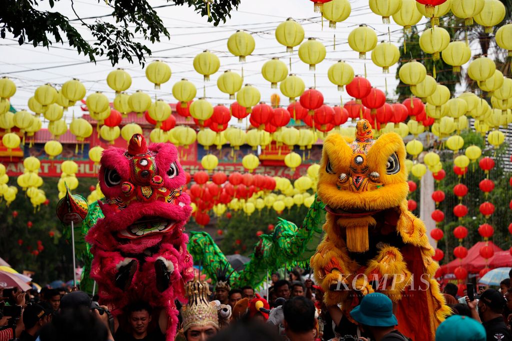 Barongsai and liong arts groups pass decorated lanterns at the Grebeg Sudiro cultural carnival event in Pasar Gede Area, Surakarta City, Central Java, Sunday (15/1/2023).