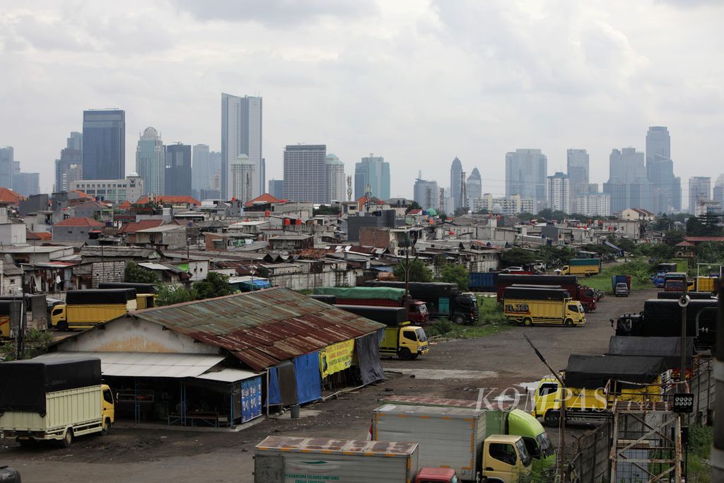 Perkampungan padat penduduk dengan latar belakang gedung bertingkat di Jakarta, Jumat (23/12/2022). Pemerintah akan melanjutkan program perlindungan sosial untuk mendorong tingkat kemiskinan pada 2023 menurun di kisaran 7,5-8,5 persen, tingkat pengangguran terbuka berkisar 5,3-6,0 persen, dan perbaikan ketimpangan (gini ratio) menjadi 0,375-0,378. 