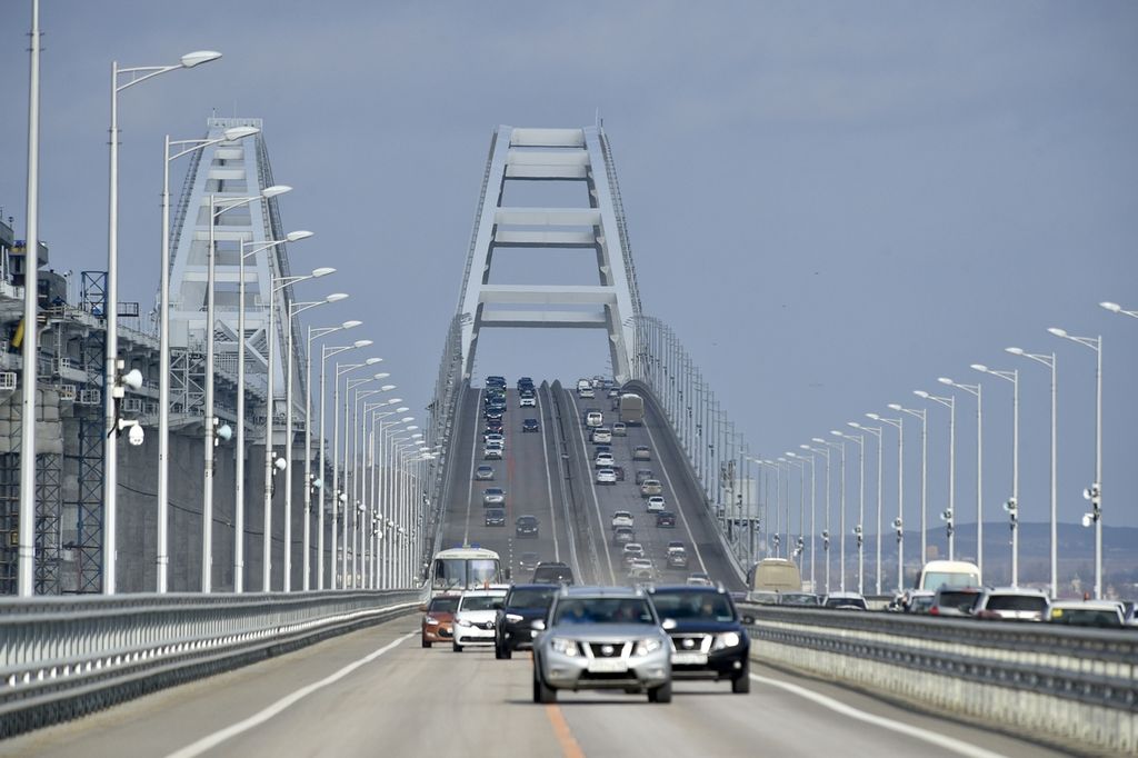 Mobil dan kendaraan lainnya melintasi Jembatan Crimea yang mengubungkan Rusia dan Semenanjung Crimea di atas Selat Kerch setelah perbaikan menyusul ledakan yang merusak jembatan, 23 Februari 2023. 