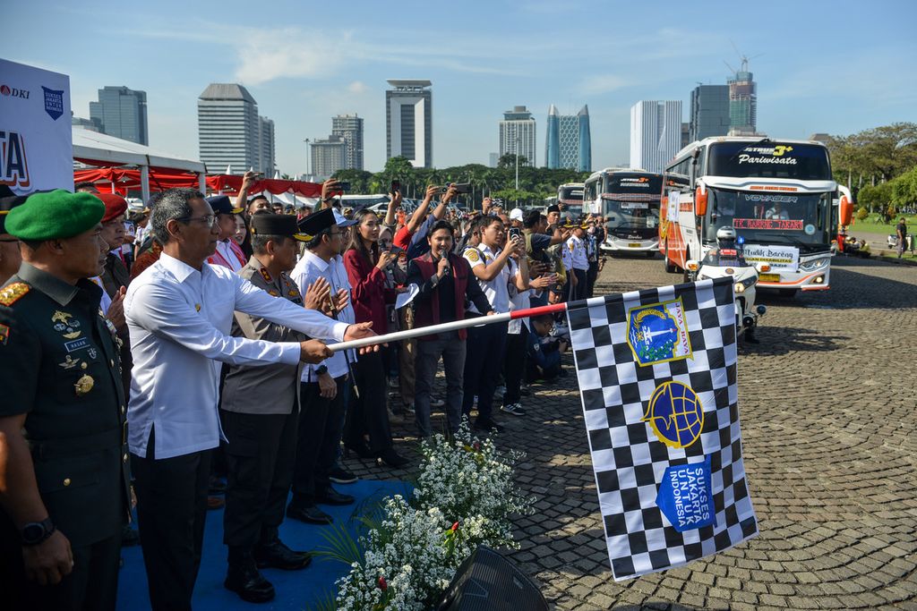 Penjabat (Pj) Gubernur DKI Jakarta Heru Budi Hartono (kedua dari kiri) melepas 284 bus mudik Lebaran 2023 gratis secara seremoni di kawasan Monas, Jakarta Pusat, Senin (17/4/2023). 