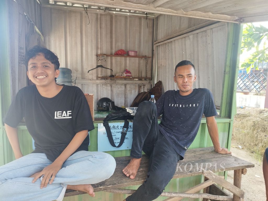 Pada sisi kanan, Mukti (27), warga Desa Nibung, tengah bertugas di loket masuk Danau Kaolin, di Desa Nibung, Kecamatan Koba, Kabupaten Bangka Tengah, Provinsi Kepulauan Bangka Belitung, Minggu (9/7/2023).