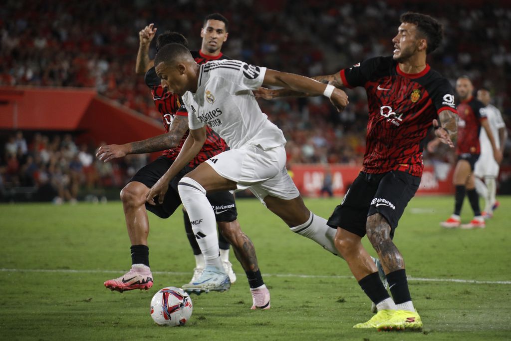 Penyerang Real Madrid Kylian Mbappe mencoba menerobos pertahanan tuan rumah Real Mallorca pada laga Liga Spanyol di Stadion Son Moix Stadium di Palma de Mallorca, Spanyol, Senin (19/8/2024) dini hari WIB. Laga itu berakhir imbang, 1-1.