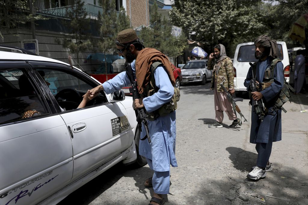 Anggota Taliban memeriksa mobil di sebuah pos pemeriksaan di Wazir Akbar Khan, kota Kabul, Afganistan, Rabu (18/8/2021). 