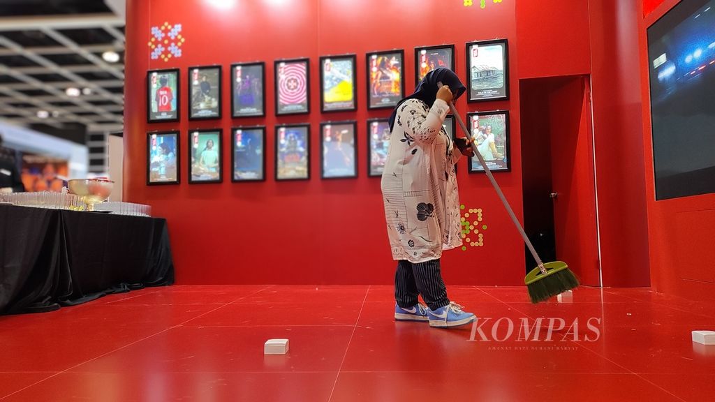 Seorang perempuan membersihkan lantai dalam ruangan yang dipakai  untuk Hong Kong Filmart
