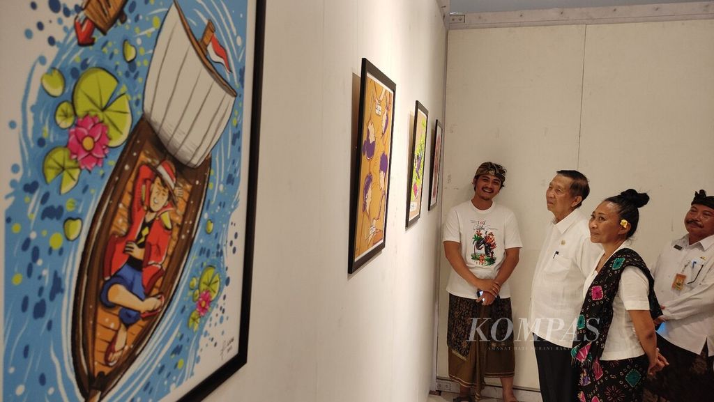 Anggota DPD RI dari Bali, yang juga Gubernur Bali dua periode (2008-2018), I Made Mangku Pastika (tengah), mengamati gambar kartun yang dipamerkan di Gedung DNA Art and Creative Hub Kota Denpasar, Bali, seusai membuka pameran tersebut pada Kamis (19/10/2023). 