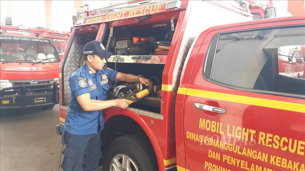 Seorang petugas melakukan pengecekan kelengkapan alat kebakaran agar siap dipakai jika mendapat panggilan bantuan.