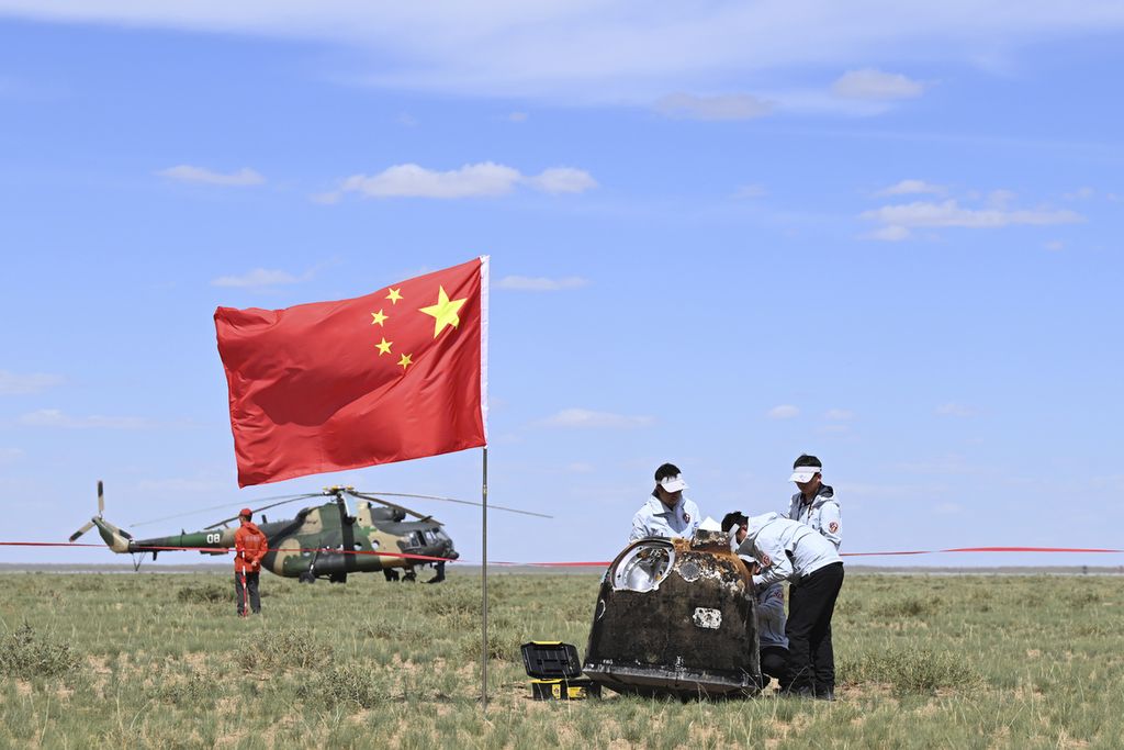 Foto yang dikeluarkan oleh Kantor Berita Xinhua ini memperlihatkan beberapa staf Badan Antariksa China tengah mengamati wahana Change-6 yang mendarat di Mongolia, Selasa (25/6/2024). 