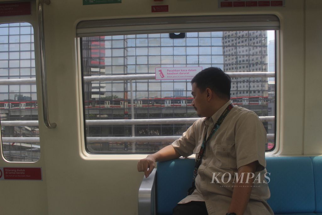 Seorang penumpang kereta ringan (LRT) Jabodebek melihat pemandangan di balik jendela ketika kereta sedang melaju, Senin (11/9/2023). 