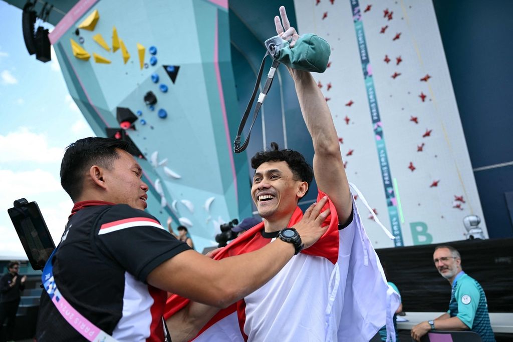  Pelatih panjat tebing Indonesia, Hendra Basir, memberikan selamat kepada Veddriq Leonardo yang baru saja meraih emas panjat tebing nomor <i>speed </i>Olimpiade Paris 2024 seusai mengalahkan atlet China, Wu Peng, di Le Bourget Sport Climbing Venue, Perancis, Kamis (8/8/2024). 