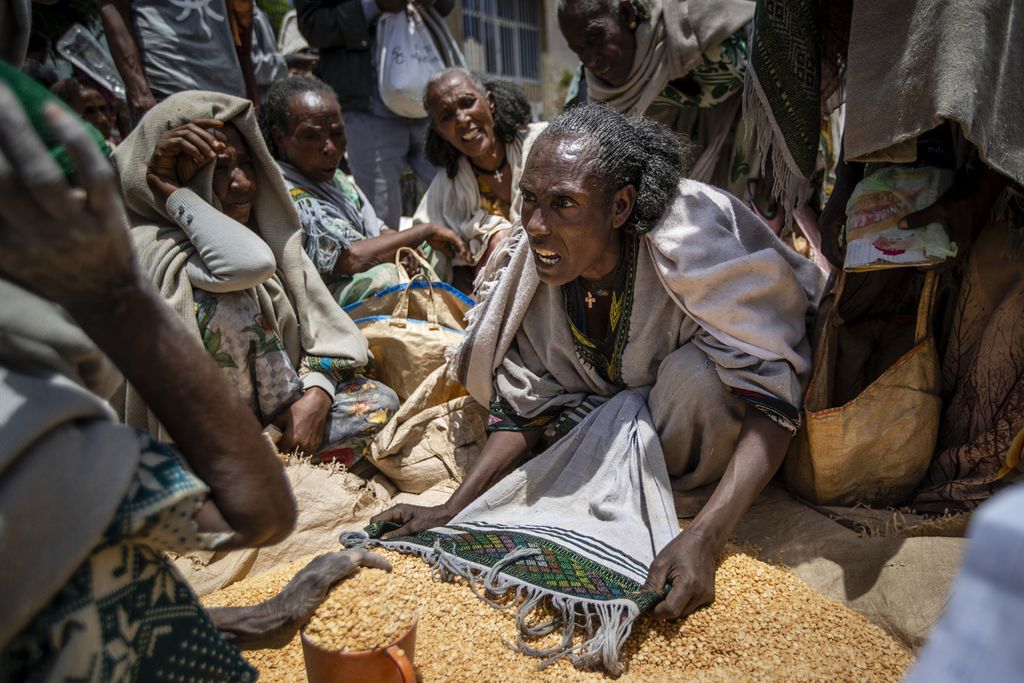 Seorang perempuan beradu argumen dengan perempuan lainnya soal pembagian kacang polong yang merupakan bantuan pangan untuk warga membutuhkan di Agula, Etiopia utara, 8 Mei 2021. Etiopia adalah salah satu penerima bantuan bahan pangan dari Program Pangan Dunia (WFP). Terhentinya Kesepakatan Laut Hitam pada Juli 2023 berpotensi pada instabilitas sosial, politik, dan keamanan di Etiopia dan sejumlah negara miskin di Afrika. 