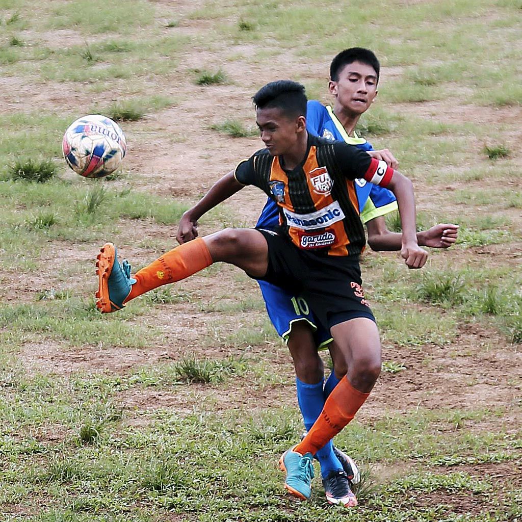 Pemain Talenta Muda FU 15 (depan)  berebut bola dengan pemain SSJ Kota Bogor  dalam laga lanjutan Liga Kompas Gramedia Panasonic U-14 di GOR Ciracas, Jakarta Timur, Sabtu (23/12). Laga berakhir imbang tanpa gol.