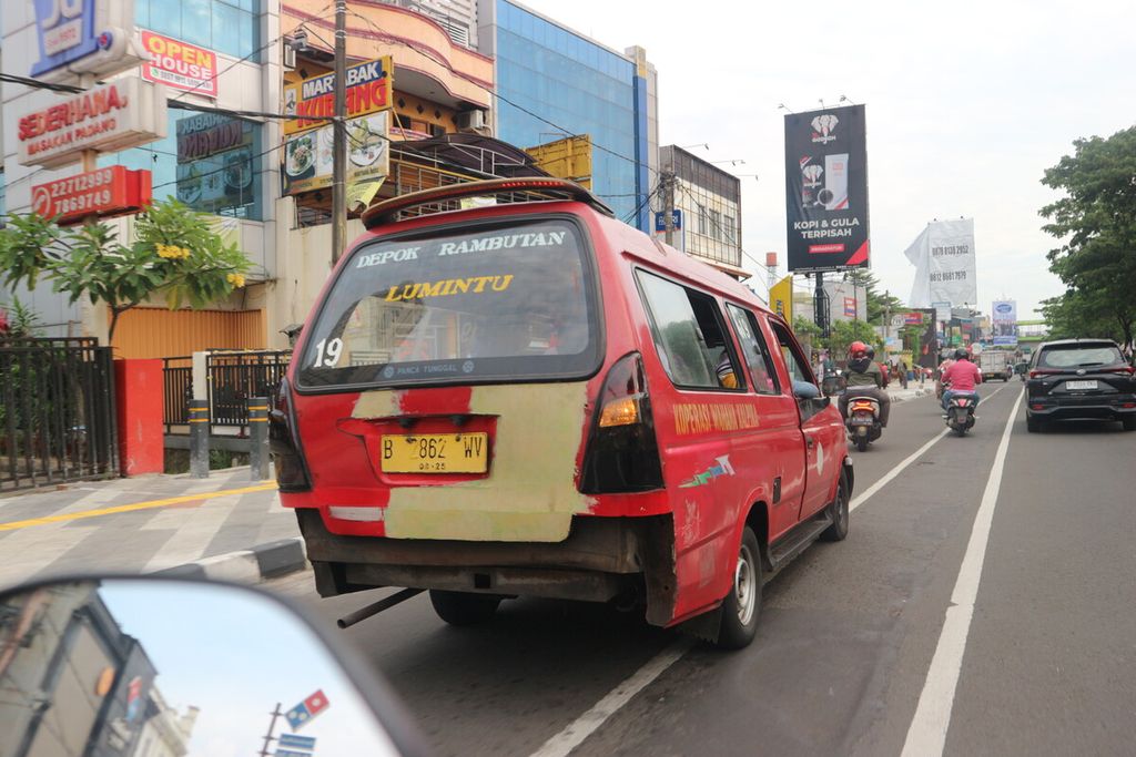 Angkot dengan trayek Depok-Rambut yang tidak memiliki bemper belakang sedang melintas di Jalan Margonda Raya, Depok, Senin (6/2/2023).