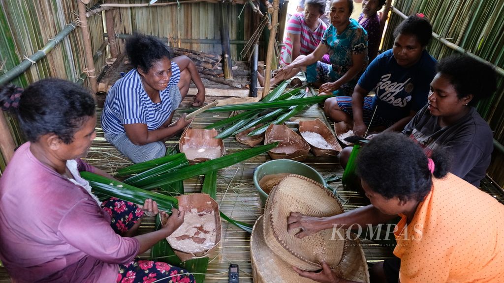 Sejumlah perempuan mengolah sagu menjadi berbagai makanan di Kampung Salafen, Distrik Misool Utara, Kabupaten Raja Ampat, Papua Barat, Jumat (29/6/2022). Ada sagu yang dicampur dengan kelapa, gula, dan sedikit air. Campuran sagu kemudian dibungkus dengan daun dan dibakar.