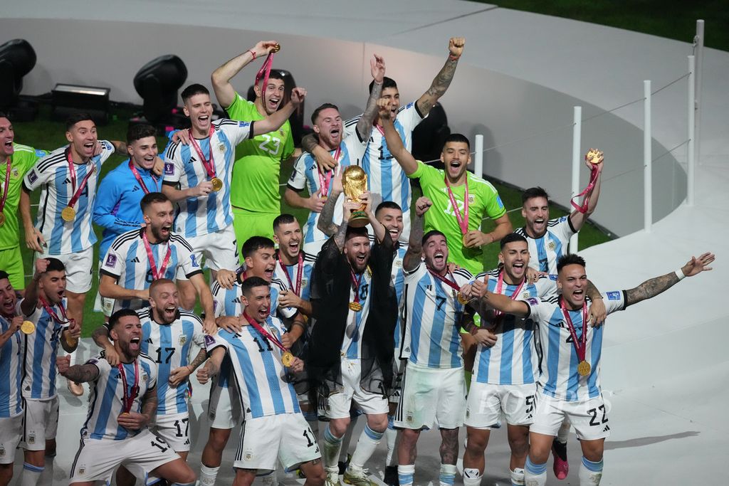 Pemain Argentina merayakan keberhasilan menjuarai Piala Dunia 2022 setelah mengalahkan Perancis lewat adu penalti di Stadion Lusail, Qatar, Senin (19/12/2022) dini hari WIB. Lionel Messi (tengah) mengangkat piala yang sudah ditunggu rakyat Argentina selama 36 tahun.