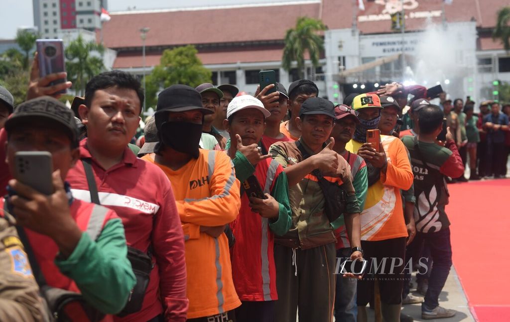Petugas kebersihan menunggu kedatangan Piala Adipura Kencana di Balai Kota, Kota Surabaya, Jawa Timur, Rabu (6/3/2024).  